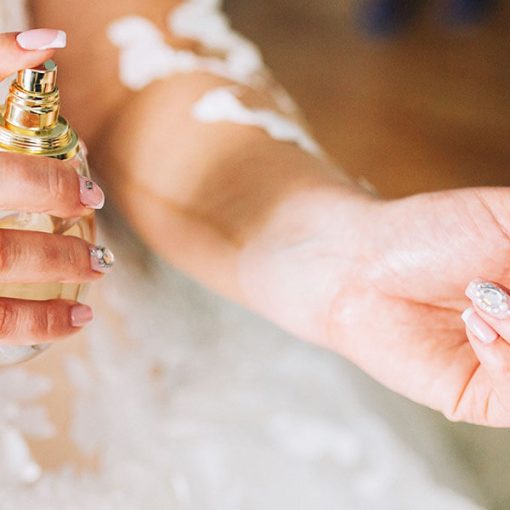Bride putting perfume on her wrist - close up