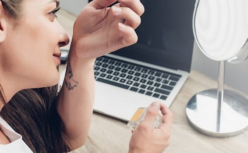 lady with tattoo smelling her wrist