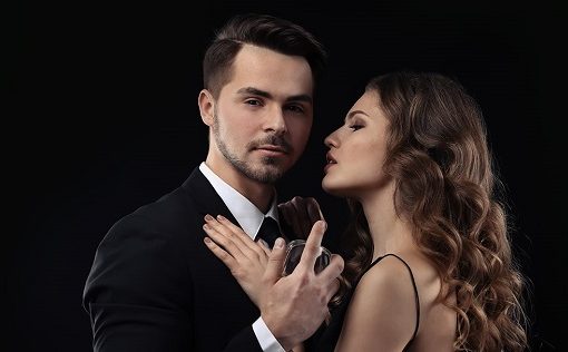 a woman embraces a man to smell his cologne