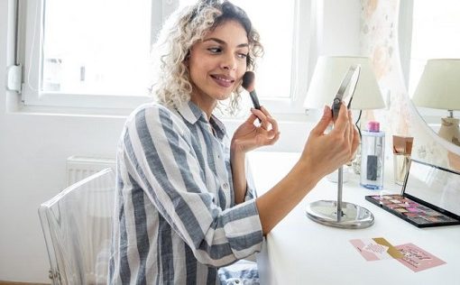 Woman looking in mirror with quote hanging