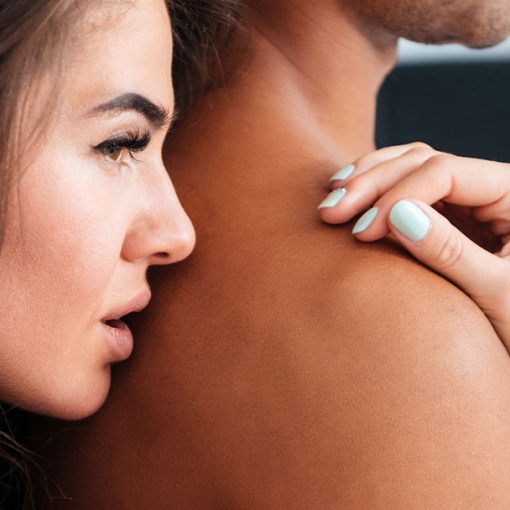 woman holding man to smell his pheromone cologne