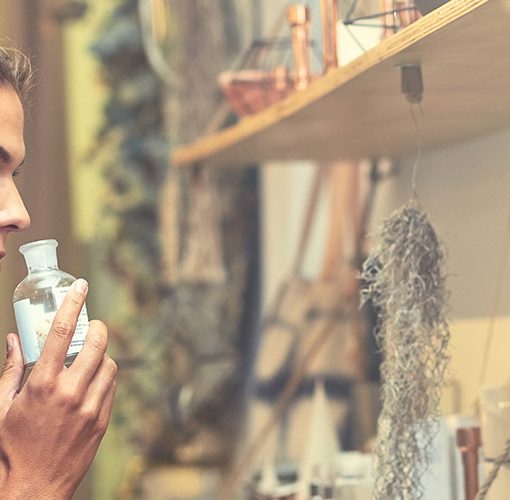 woman smelling perfume in store