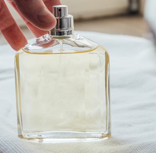 man grabbing cologne bottle