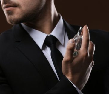 gentleman spraying cologne on himself