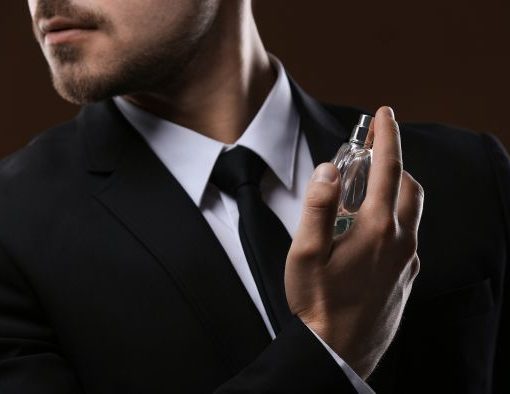 gentleman spraying cologne on himself