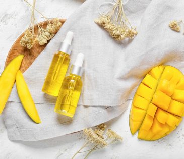 Composition with mango essential oil and bath supplies on light background