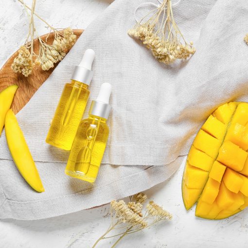 Composition with mango essential oil and bath supplies on light background