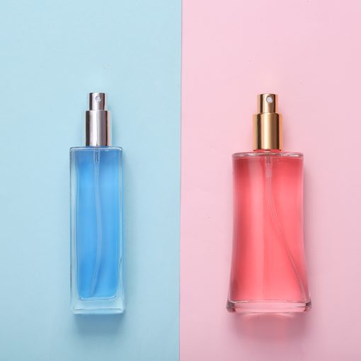Blue and pink perfume bottle on two tone pastel background. Top view