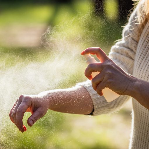 Insect repellent. Woman applying mosquito repellent
