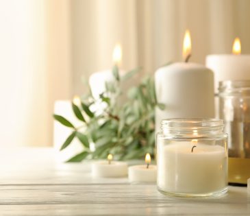 Burning scented candles for relax on white wooden table
