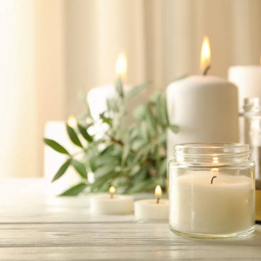 Burning scented candles for relax on white wooden table